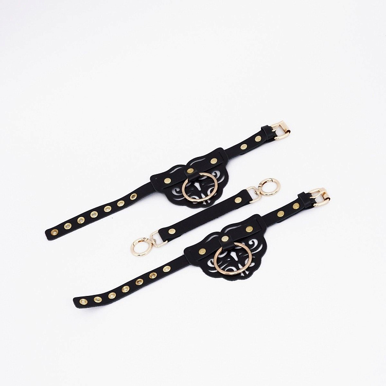 Черные кожаные оковы с резными узорами и клепками